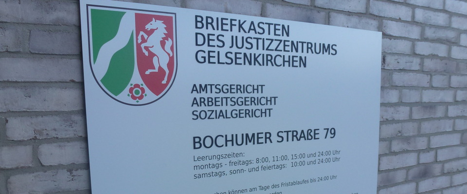 oberer Teil eines Schildes am Gebäude mit Beschriftung zum Briefkasten des Justizzentrums Gelsenkirchen